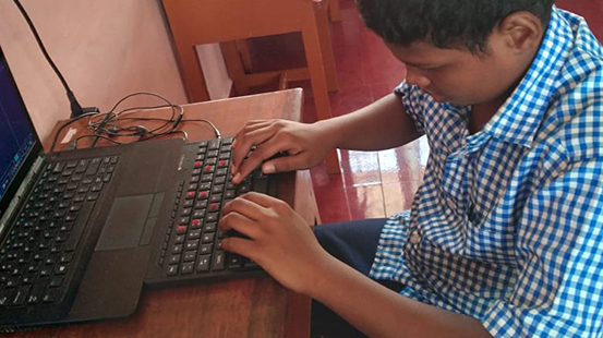 visually disabled boy using a keyboard